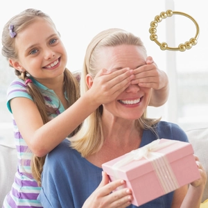 Close-up of golden spinning bead anxiety ring presented in a pink gift box for women