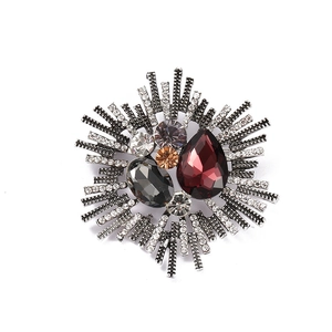 Baroque rhinestone brooch with deep red and amber gemstones on dark metal base