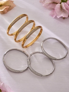 Vue détaillée des bracelets joncs dorés et argentés avec pavé de zircons et fermoir