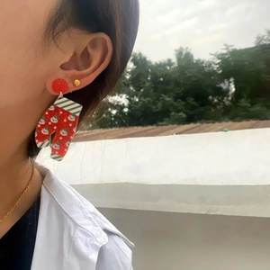 Close-up of Santa Claus acrylic drop earring worn on model showing holiday details