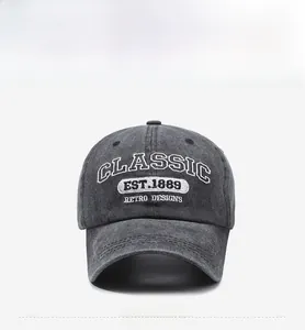 Close-up of retro charcoal grey washed denim baseball cap with classic white embroidery