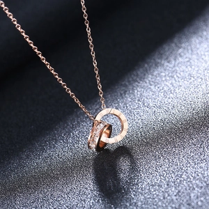 Detail of rose gold double-ring necklace with Roman numerals and sparkling crystals