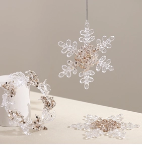 Macro detail of transparent acrylic snowflake and wreath ornaments with gold sequins