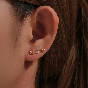 Close-up of s925 silver 16G gold cartilage studs in star, rhombus, and cluster designs