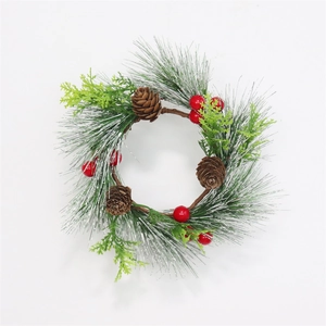 Verschneiter Weihnachts-Kerzenkranz mit Kiefernadeln, roten Beeren und Zapfen vor weiß
