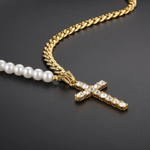 Détail macro du collier chaîne cubaine dorée et perles avec pendentif croix glacée