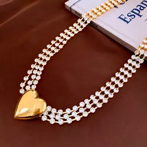 Three-row rhinestone body chain with a large golden heart pendant on vintage background