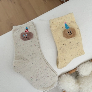Detail of cute bear embroidery and colorful dotted yarn texture on crew socks