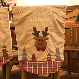 Weihnachtliche Stuhlhussen in Kamelbraun mit Rentier-Stickerei und festlichem Design