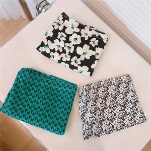 Detail view of foldable green printed cotton tote bags with various floral patterns