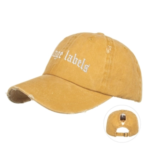 Vue détaillée de la casquette jaune moutarde avec trou pour queue de cheval et broderie