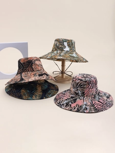 Close-up of double-sided wide brim sun hats with tropical palm leaf print patterns