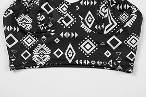 Vue détaillée du crop top noir avec imprimés géométriques tribaux et coutures fines