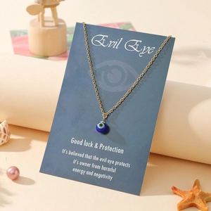 Macro view of blue evil eye amulet pendant on gold chain with beach shells decoration