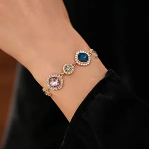 Vintage gold-plated bracelet with multi-colored crystals and diamond-paved borders on wrist