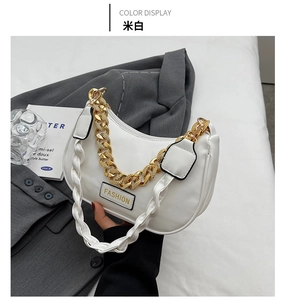 Detail of off-white crescent handbag featuring a chunky gold chain and fashion lettering
