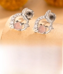 Detail of fishtail earrings featuring pink zircon and silver-toned titanium steel