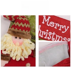 Detail view of 3D Santa Claus Christmas stocking with Merry Christmas print and plush pom-poms