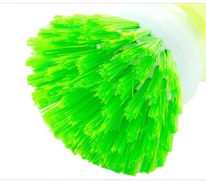 Macro view of tight bright green plastic bristles on the round kitchen cleaning brush