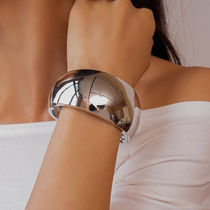 Macro detail of high-polish silver wide cuff bracelet with metallic irregular surface