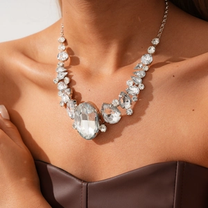 Detailed view of large teardrop and oval rhinestone necklace on model for gala events