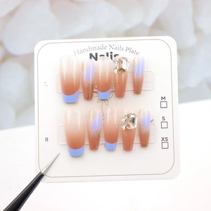 Detail of long coffin nails with pink gradient, blue french tips and crystal rhinestones