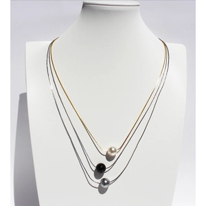 Three-layer necklace with white, grey, and black pearls on gold and silver chains