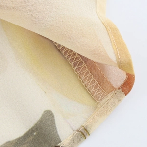 Detailaufnahme der Overlock-Naht und Textur auf dem floralen Chiffon-Stoff
