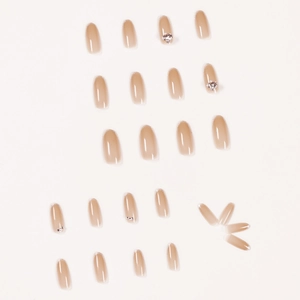 Faux ongles ombrés français avec bords argentés et strass sur un fond blanc neutre