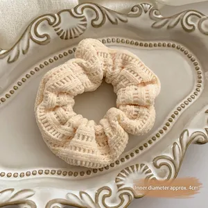 Detail view of a beige corduroy scrunchie with 4cm inner diameter on a ceramic tray