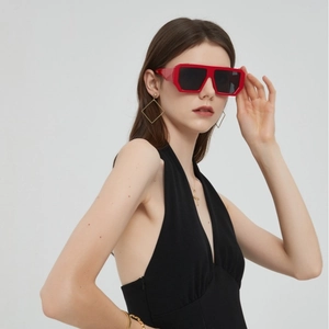 Fashionable women's square red sunglasses with black lenses and golden jewelry details