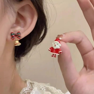 Detail of Christmas Santa and festive bow earrings with bells on a female model