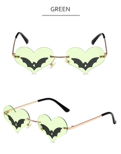 Detail of rimless heart-shaped sunglasses with green lenses and black bat accent