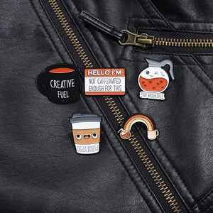 Détail de cinq pin's en émail sur le thème du café sur une veste en cuir noir stylée