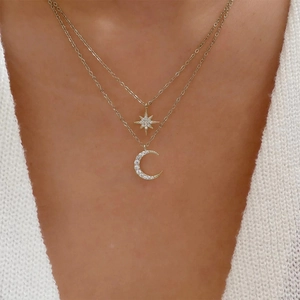 Detail of layered gold S925 silver necklace with micro-pave star and moon pendants