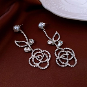 Close-up of rose pearl drop earrings with silver plating and sparkling rhinestones