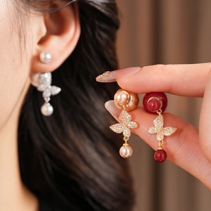Detailed view of vintage gold plated butterfly pearl earrings with sparkling zircons