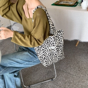 Detail of leopard print canvas tote bag featuring an artistic Korean woven label