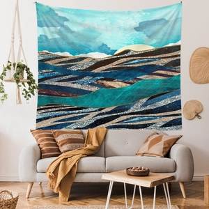 Detail of abstract mountain wall tapestry hanging above a modern sofa in a living room