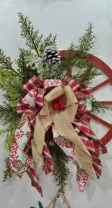 Christmas wooden wheel wreath with red berries, pine needles and festive ribbons decoration