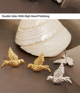 Detaillierte Makroansicht der Vogel-Ohrstecker in Gold und Silber, handpoliertes Finish