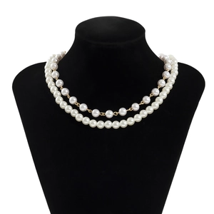 Detail of double-layer necklace with white faux pearls and gold chain on display