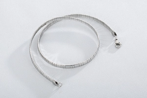 Gros plan d'un collier chaîne serpent plate en acier inoxydable argenté poli
