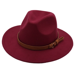 Detail of burgundy felt fedora hat featuring a brown leather band and metal ring accent