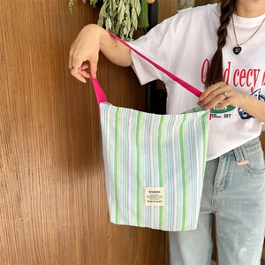 Détail du cabas en toile à rayures avec bandoulière rose et étiquette de marque