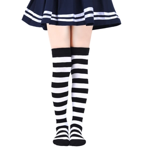 Close-up of black and white striped knee-high knit socks paired with a navy pleated skirt