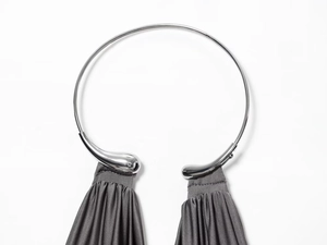 Detail of silver metallic collar with elegant dark grey pleated fabric textures