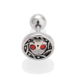 Macro shot of silver stainless steel earring with red stone eyes on alien skull design