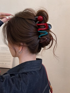 Detailed view of wave-shaped color-block hair claw clip worn on a bun hairstyle
