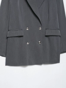 Vue détaillée du blazer croisé gris foncé avec boutons argentés et poches à rabat